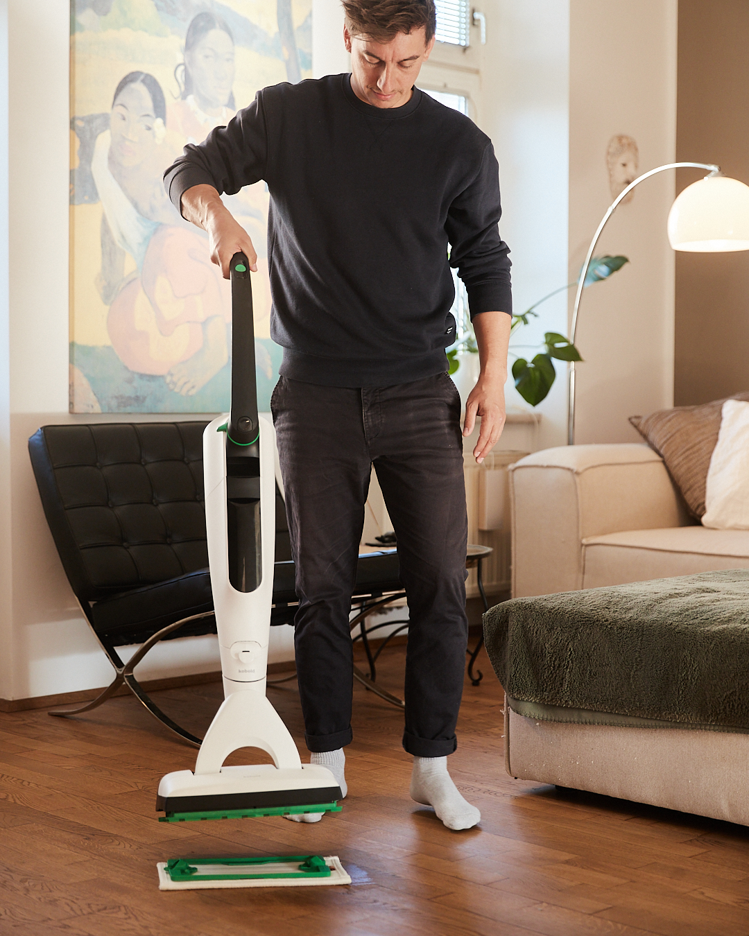 Mann wechselt das Reinigungspad am Kobold SP7 im Wohnzimmer – Detailaufnahme aus der aime Kampagne „Mental (un)load“ für Vorwerk.