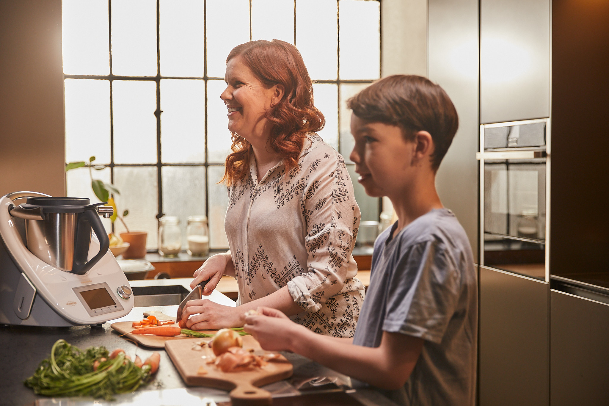 Familienküche mit Thermomix – Mutter und Kind beim gemeinsamen Kochen als Teil der aime Jubiläumskampagne für Thermomix Österreich.